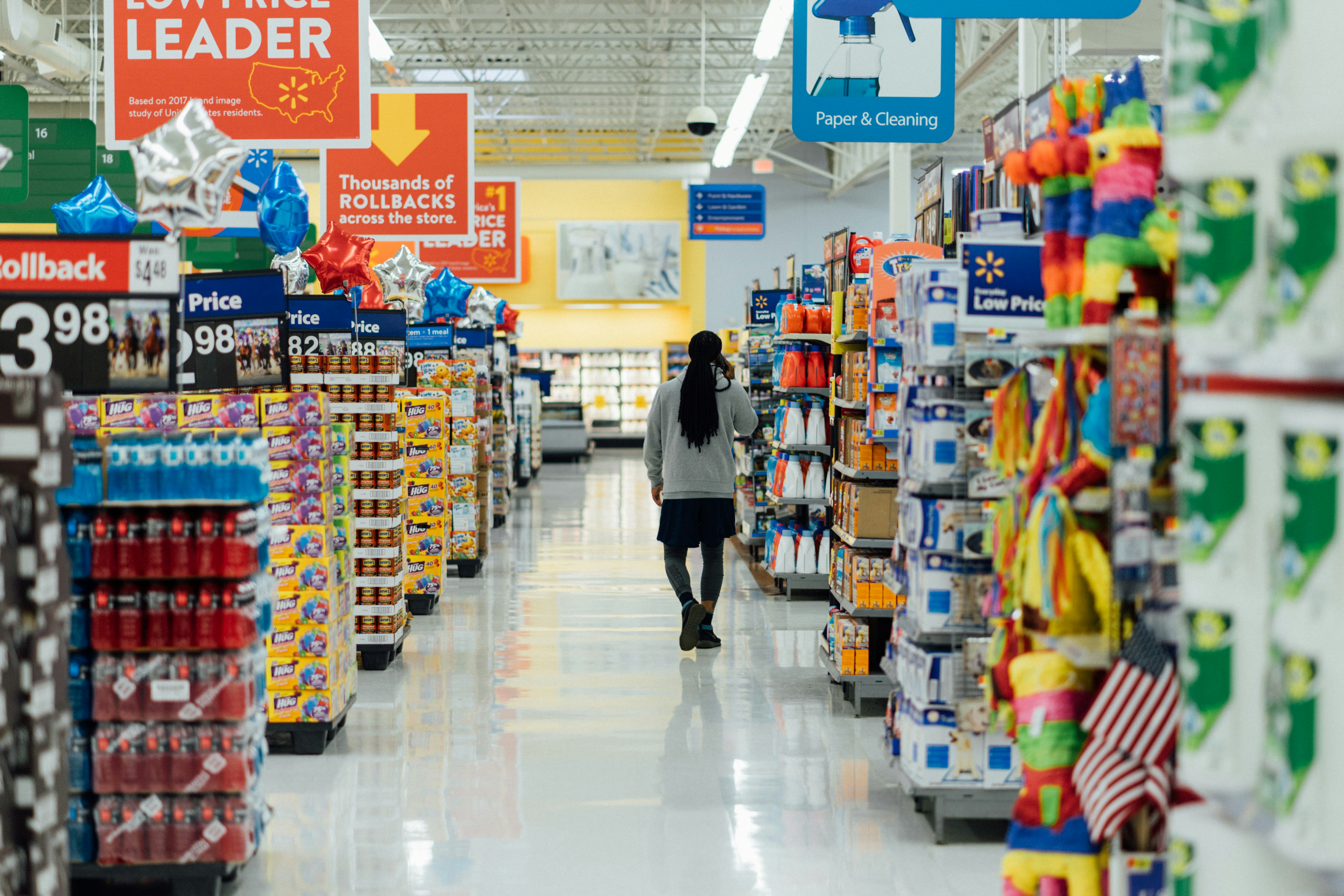 Person standing between grocery store shelving aisles